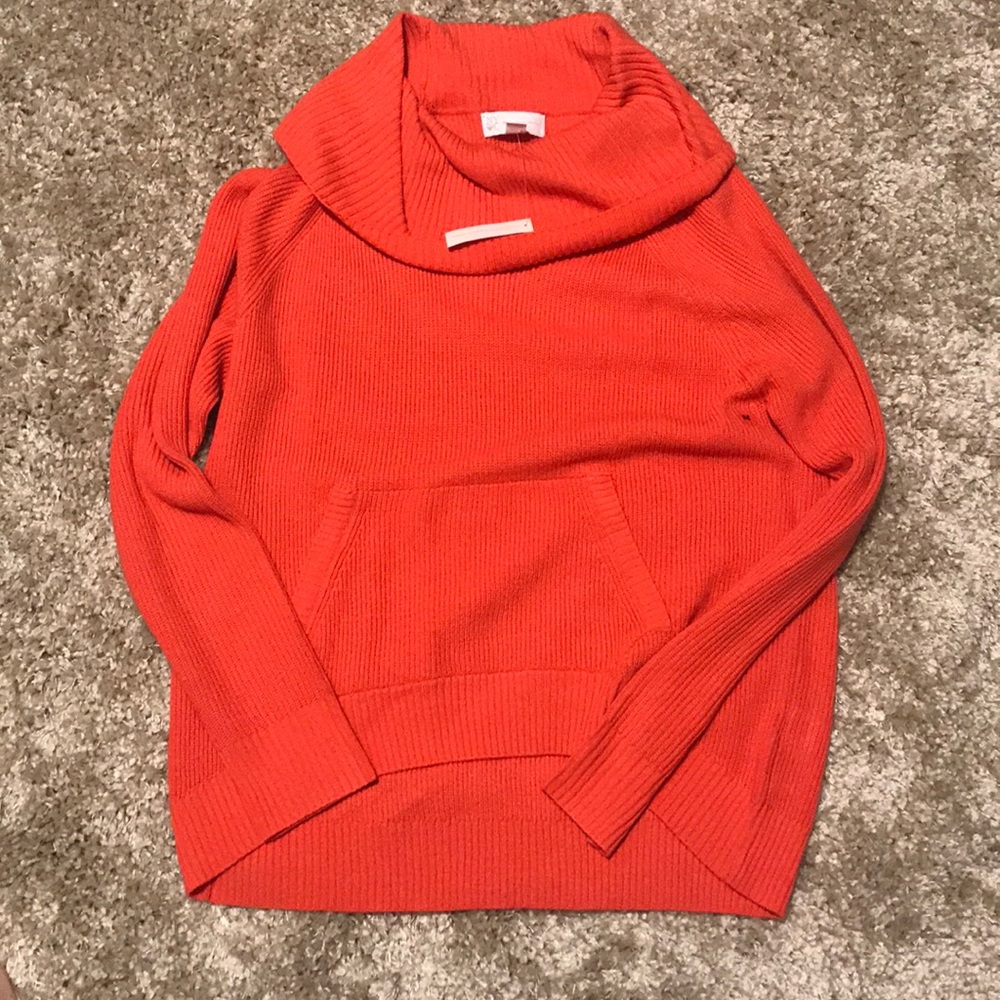 Salmon colored sweater with hoodie pocket.